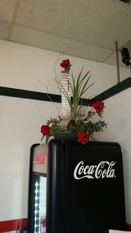 Coca-Cola refrigerator with flower arrangement on top