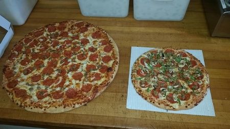 One large and one small pizza beside each other